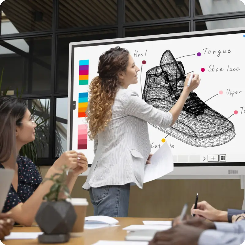 Creative person editing shoe design on a digital interactive whiteboard