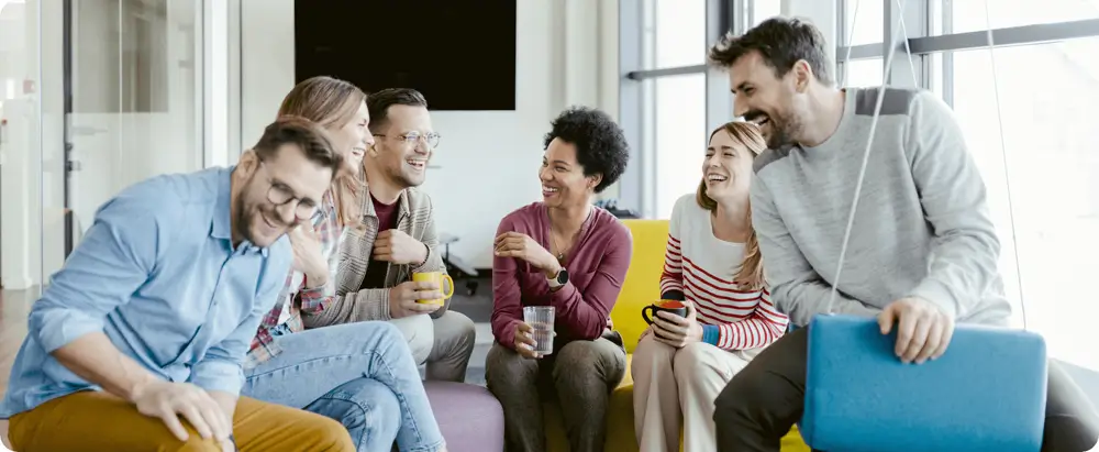 Group of six people laughing and having a discussion