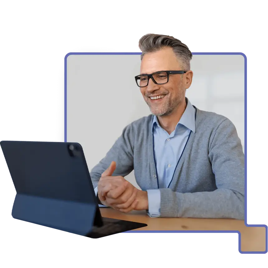 Smiling man with glasses looking at a tablet